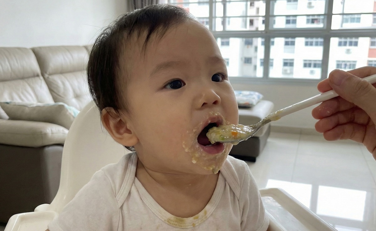 A baby in Singapore being fed healthy porridge.