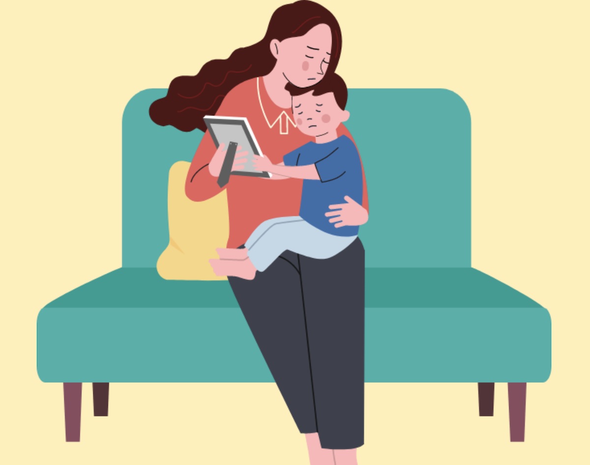 A parent comforting a young teenager on a bench.