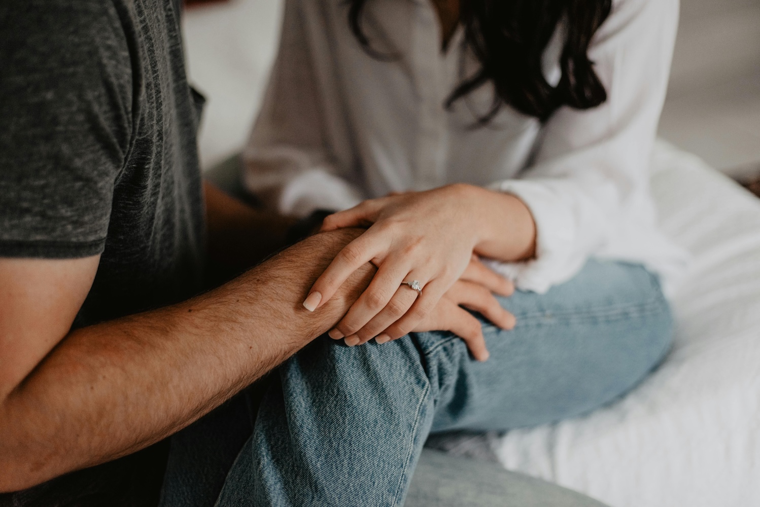 A couple holding hands in the bedroom