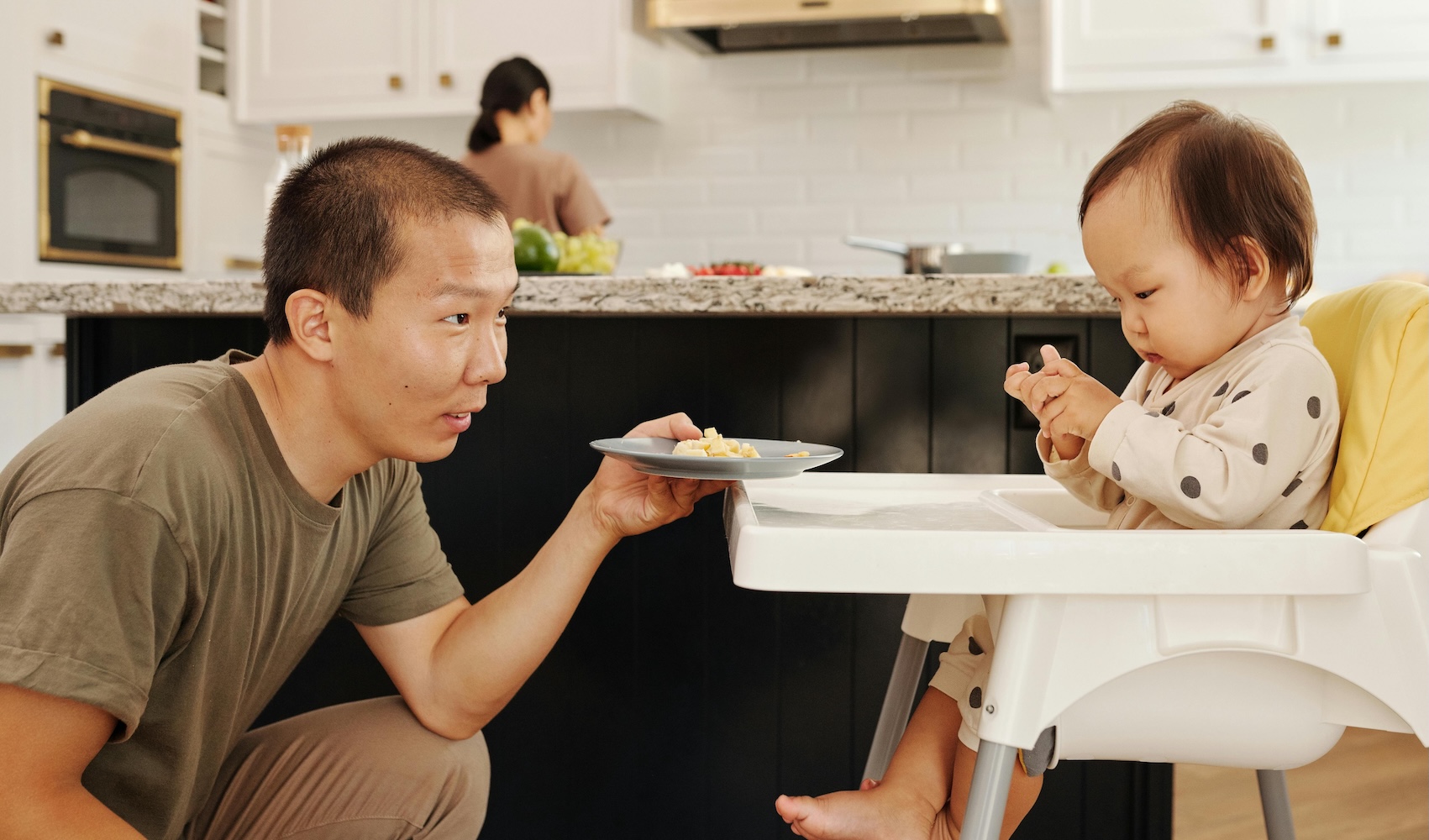 parent trying to coax toddler to eat